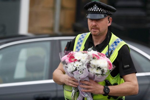 Floral tributes left by well-wishers were taken inside the police cordon by officers.