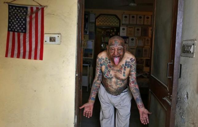 Guinness Rishi, 74, multiple world record holder including most flags tattooed on his body, poses for a photograph outside his apartment in New Delhi, India May 20, 2016. REUTERS/Cathal McNaughton