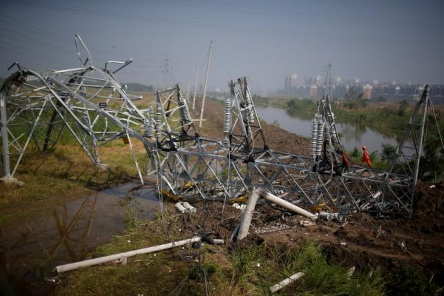 A rescue worker works on a damaged high-voltage tower after a tornado hit Funing on Thursday, in Yancheng, Jiangsu province, June 25, 2016. REUTERS/Aly Song