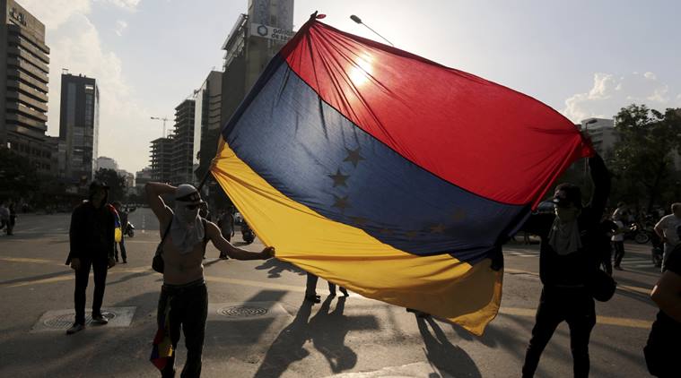 Demonstrators hold a Venezuelan flag upside down